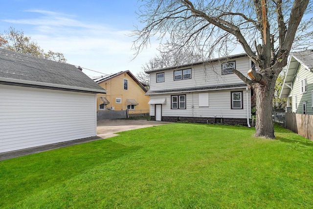back of property featuring driveway, a garage, fence, a yard, and a patio