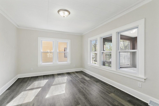 empty room featuring baseboards, visible vents, ornamental molding, and dark wood-type flooring