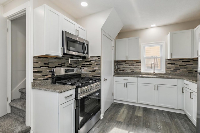 kitchen featuring decorative backsplash, a sink, stainless steel appliances, white cabinetry, and dark wood-type flooring