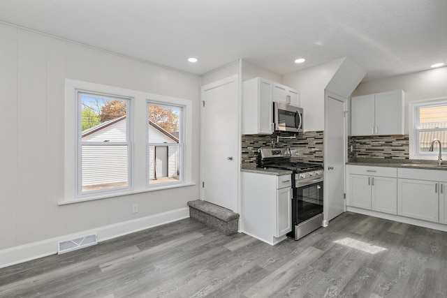 kitchen featuring stainless steel appliances, visible vents, a sink, and light wood-style floors