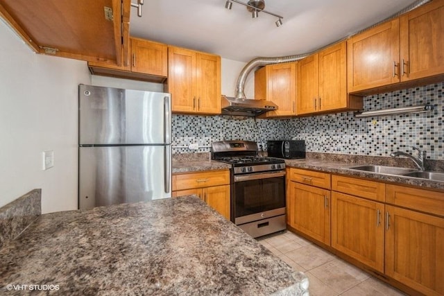 kitchen with light tile patterned floors, appliances with stainless steel finishes, decorative backsplash, and a sink
