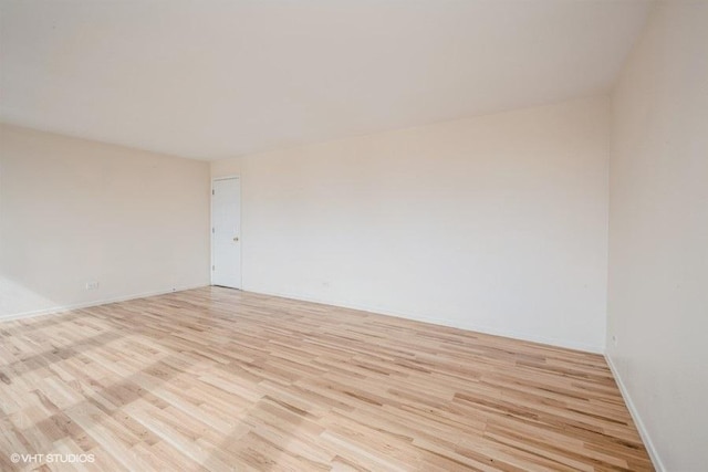 unfurnished room featuring baseboards and light wood-style flooring