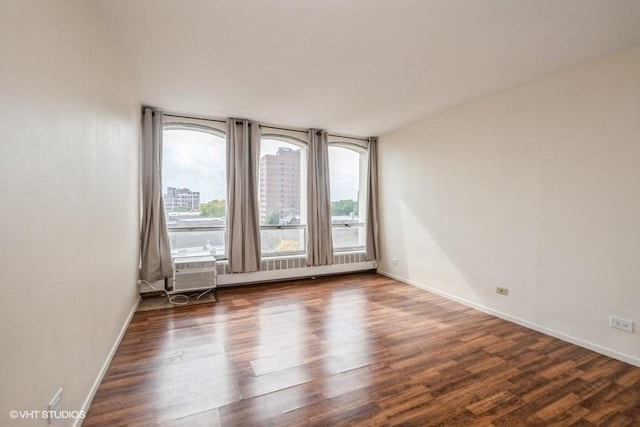 spare room featuring baseboards and wood finished floors