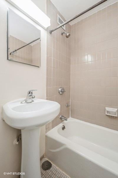 full bathroom featuring tile patterned flooring, visible vents, and bathing tub / shower combination