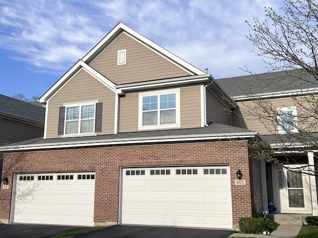 view of front facade with brick siding, driveway, and a garage