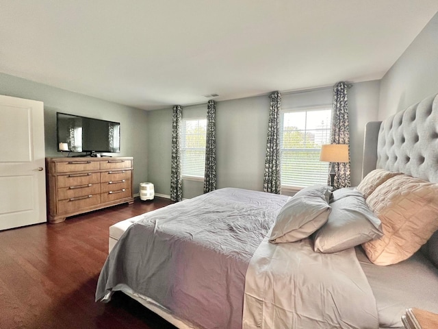 bedroom with baseboards, dark wood-style floors, and visible vents