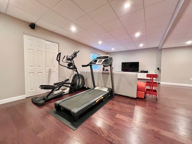 exercise room with baseboards and hardwood / wood-style floors