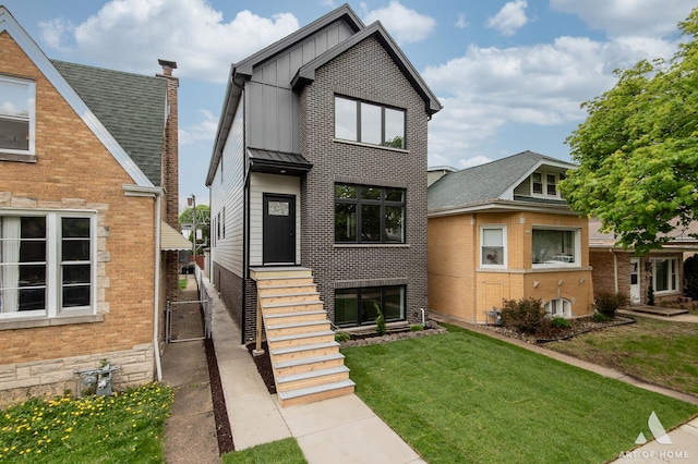 6908 26th St, Berwyn, IL 60402 - view of front of property with board and batten siding, brick siding, fence, a front lawn, and a gate