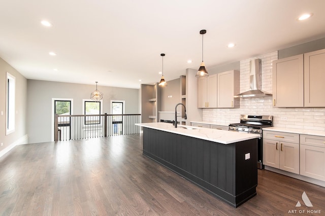 6908 26th St, Berwyn, IL 60402 - kitchen with a sink, wall chimney exhaust hood, stainless steel gas range oven, a kitchen island with sink, and decorative backsplash