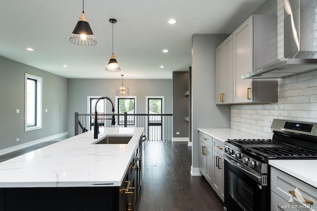 6908 26th St, Berwyn, IL 60402 - kitchen featuring baseboards, gas stove, a sink, wall chimney exhaust hood, and a center island with sink