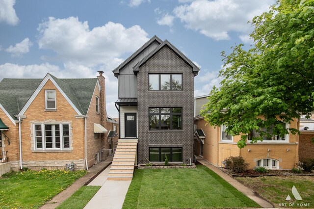 6908 26th St, Berwyn, IL 60402 - view of front of house featuring a front yard, a standing seam roof, brick siding, and metal roof