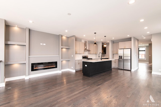 6908 26th St, Berwyn, IL 60402 - kitchen with wall chimney range hood, a center island with sink, open floor plan, light countertops, and appliances with stainless steel finishes