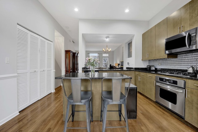 1455 S Halsted St, Chicago, IL 60607 - kitchen featuring tasteful backsplash, a chandelier, light wood-style floors, a breakfast bar, and stainless steel appliances