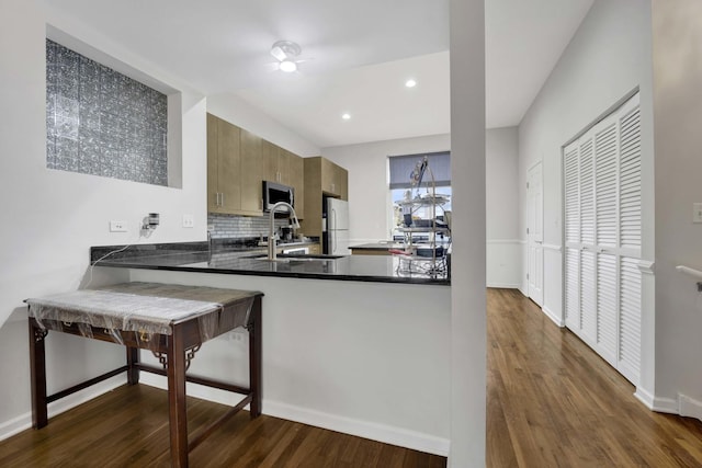 1455 S Halsted St, Chicago, IL 60607 - kitchen with dark wood-style flooring, tasteful backsplash, freestanding refrigerator, stainless steel microwave, and a peninsula