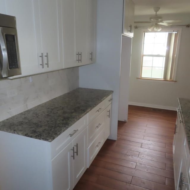 457 N Cambridge Dr Unit 457, Palatine, IL 60067 - kitchen with ceiling fan, light stone counters, dark wood finished floors, stainless steel microwave, and decorative backsplash