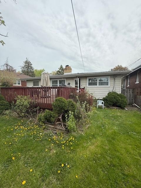 1304 Price Ave, Calumet City, IL 60409 - back of property with a lawn, fence, a wooden deck, and a chimney