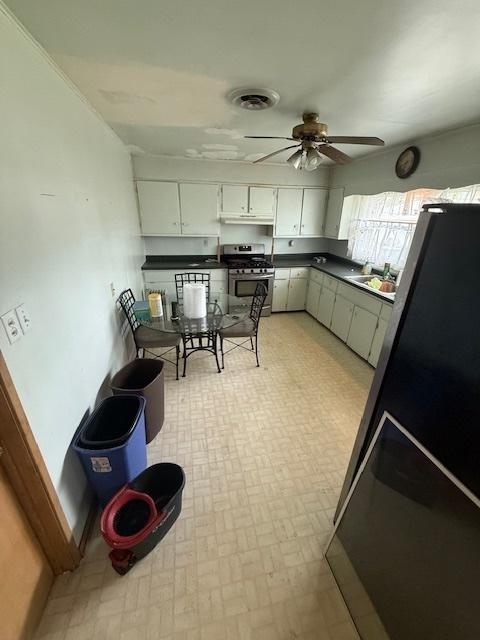 1304 Price Ave, Calumet City, IL 60409 - kitchen featuring white cabinets, dark countertops, ceiling fan, a sink, and stainless steel gas stove