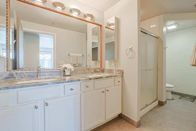77 S Evergreen Ave Unit 1004, Arlington Heights, IL 60005 - bathroom featuring a stall shower, toilet, double vanity, and baseboards