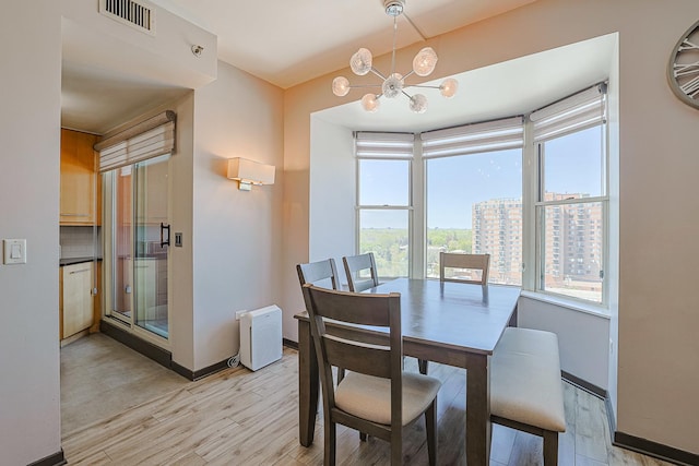 77 S Evergreen Ave Unit 1004, Arlington Heights, IL 60005 - dining space with a chandelier, light wood-type flooring, and baseboards