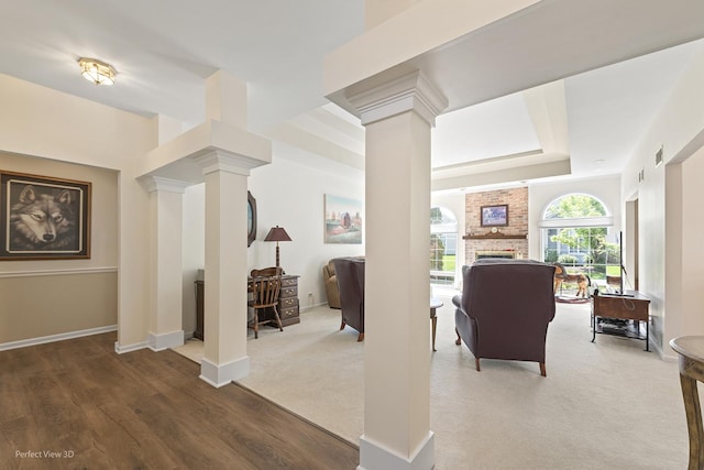 36225 N Goldspring Ct, Gurnee, IL 60031 - living room featuring decorative columns, a raised ceiling, a brick fireplace, baseboards, and wood finished floors