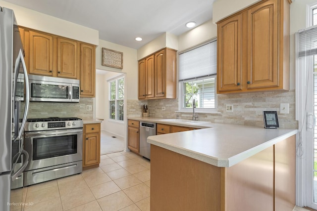 36225 N Goldspring Ct, Gurnee, IL 60031 - kitchen featuring appliances with stainless steel finishes, a sink, a peninsula, light tile patterned flooring, and plenty of natural light