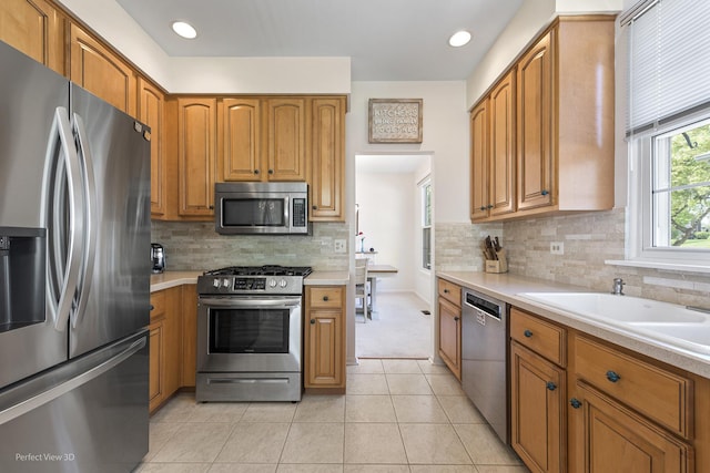 36225 N Goldspring Ct, Gurnee, IL 60031 - kitchen featuring appliances with stainless steel finishes, light countertops, a sink, brown cabinetry, and light tile patterned floors