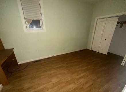 5217 S Ingleside Ave, Chicago, IL 60615 - unfurnished bedroom featuring baseboards, a closet, and dark wood finished floors