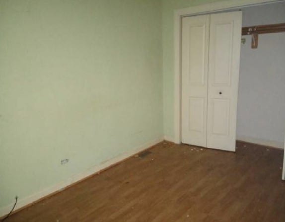 5217 S Ingleside Ave, Chicago, IL 60615 - unfurnished bedroom featuring baseboards, a closet, and wood finished floors