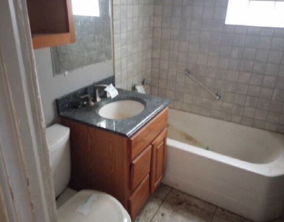 5217 S Ingleside Ave, Chicago, IL 60615 - full bath with tile patterned floors, vanity, toilet, and a wealth of natural light