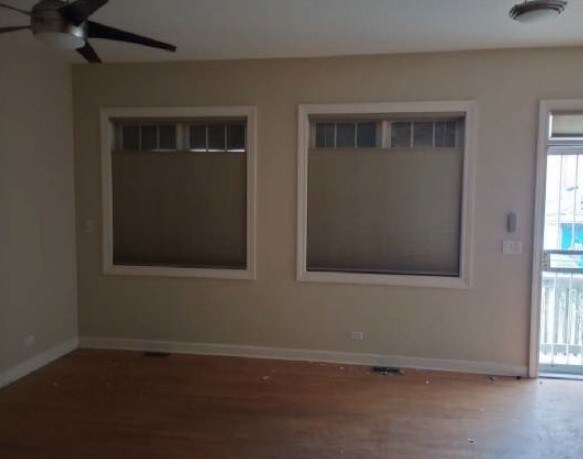 5217 S Ingleside Ave, Chicago, IL 60615 - unfurnished room with baseboards, ceiling fan, a wealth of natural light, and wood finished floors