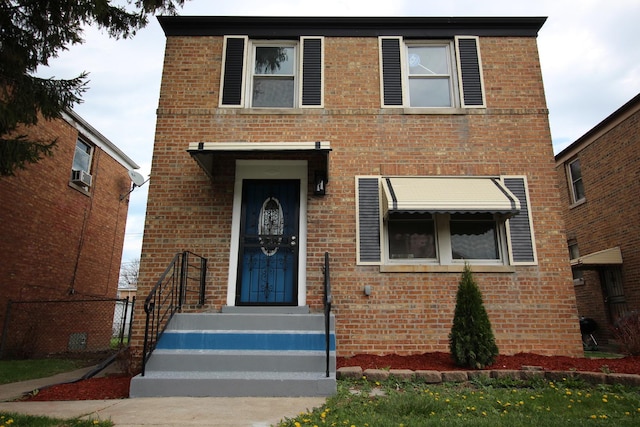 view of front facade with brick siding and fence