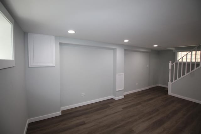 below grade area featuring stairs, recessed lighting, baseboards, and dark wood-type flooring