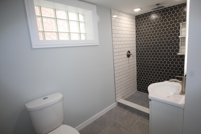 full bathroom featuring vanity, toilet, baseboards, tile patterned floors, and a tile shower
