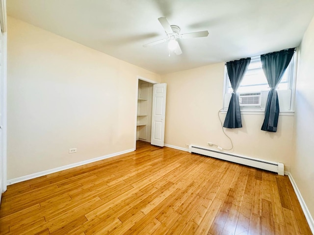 unfurnished bedroom featuring baseboard heating, cooling unit, a ceiling fan, baseboards, and light wood-type flooring