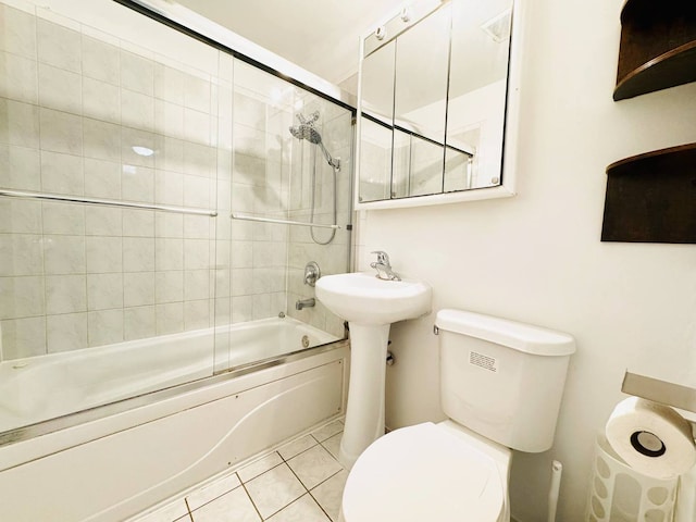 full bath featuring bath / shower combo with glass door, tile patterned flooring, and toilet