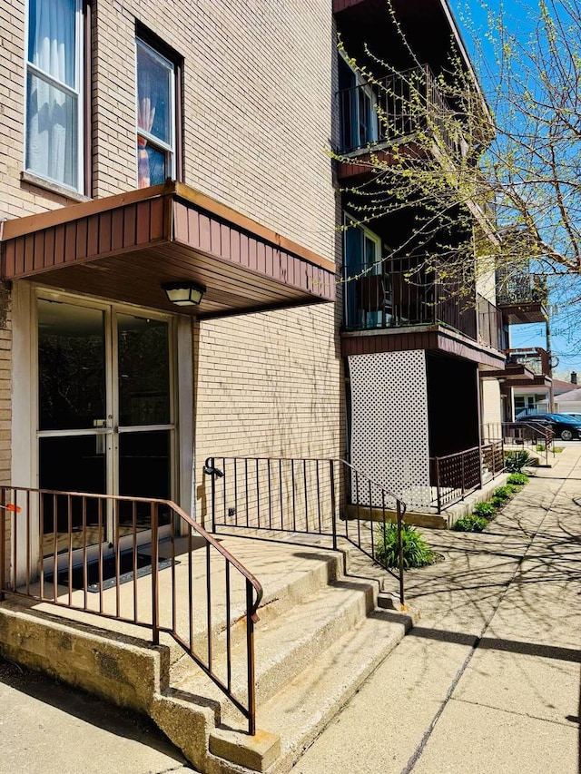doorway to property featuring brick siding