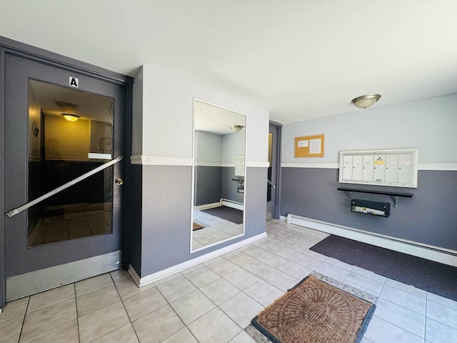 bathroom featuring baseboards, tile patterned flooring, and a baseboard radiator