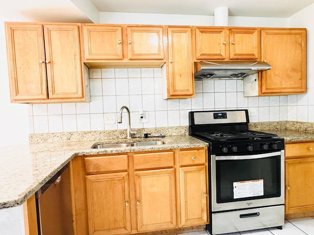 kitchen with light stone countertops, stainless steel range with gas cooktop, under cabinet range hood, a sink, and backsplash
