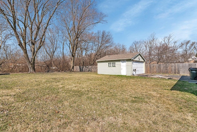 view of yard featuring an outdoor structure, a garage, and fence