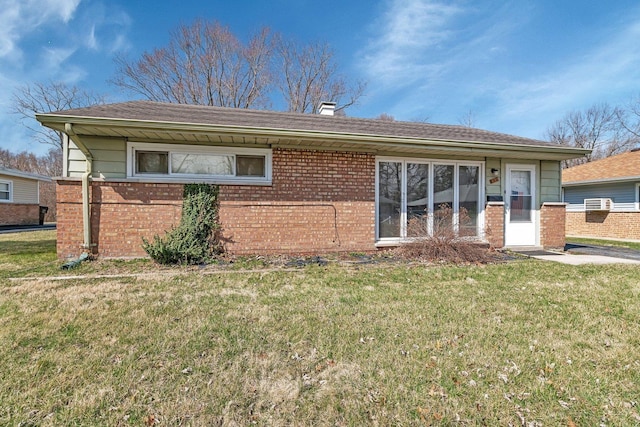 view of front facade with a chimney, a front lawn, and brick siding
