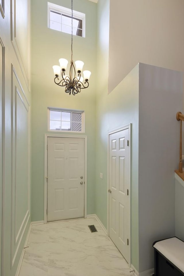 3412 Blue Ridge Dr, Carpentersville, IL 60110 - foyer entrance with a towering ceiling, a chandelier, light marble finish floors, baseboards, and plenty of natural light