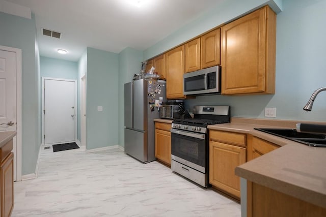 3412 Blue Ridge Dr, Carpentersville, IL 60110 - kitchen with appliances with stainless steel finishes, a sink, light countertops, light marble finish floors, and baseboards