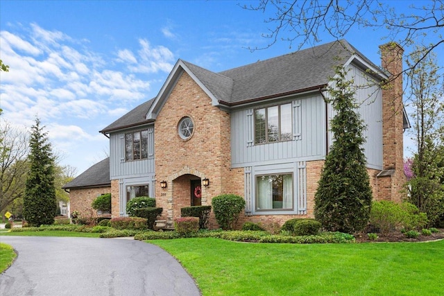 301 Hambletonian Dr, Oak Brook, IL 60523 - view of front of property with a chimney, board and batten siding, brick siding, and a front lawn