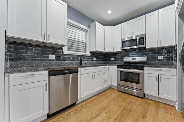 5052 W Huron St, Chicago, IL 60644 - kitchen with dark stone counters, white cabinetry, light wood finished floors, and stainless steel appliances