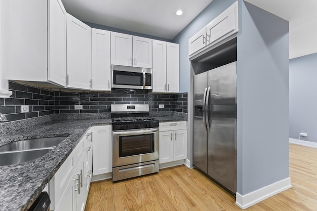 5052 W Huron St, Chicago, IL 60644 - kitchen with baseboards, light wood-type flooring, a sink, backsplash, and stainless steel appliances