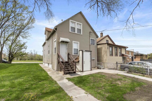 1319 Washington St, Chicago Heights, IL 60411 - rear view of house with a lawn, fence, and entry steps
