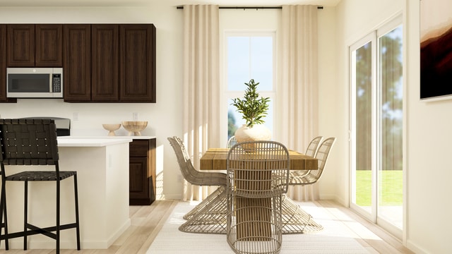 dining space featuring baseboards, a wealth of natural light, and light wood-style floors