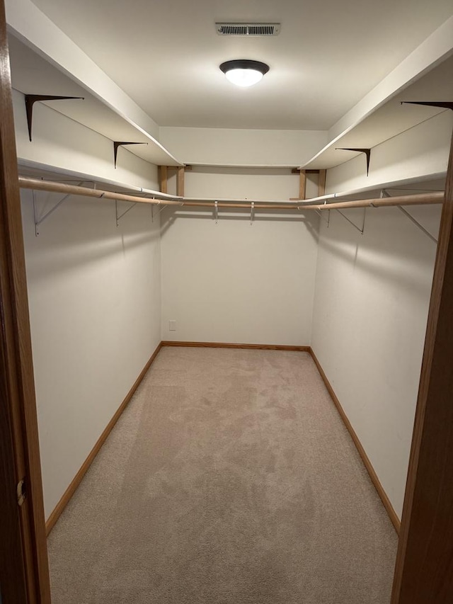 walk in closet featuring visible vents and light colored carpet
