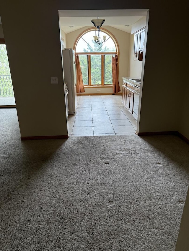 hall with baseboards, light tile patterned floors, and light carpet
