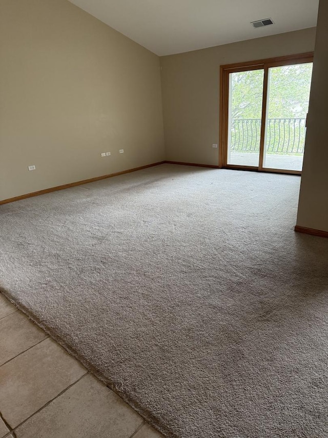 carpeted empty room with visible vents and baseboards